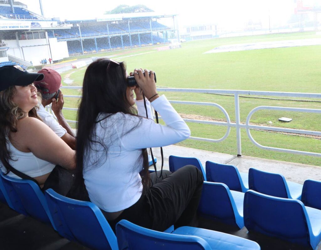 (FILE) A cricket fan looks through her binoculars during the first day a Test match between West Indies and South Africa, on August 7, 2024 at the Queen's Park Oval, St Clair.  - Angelo Marcelle