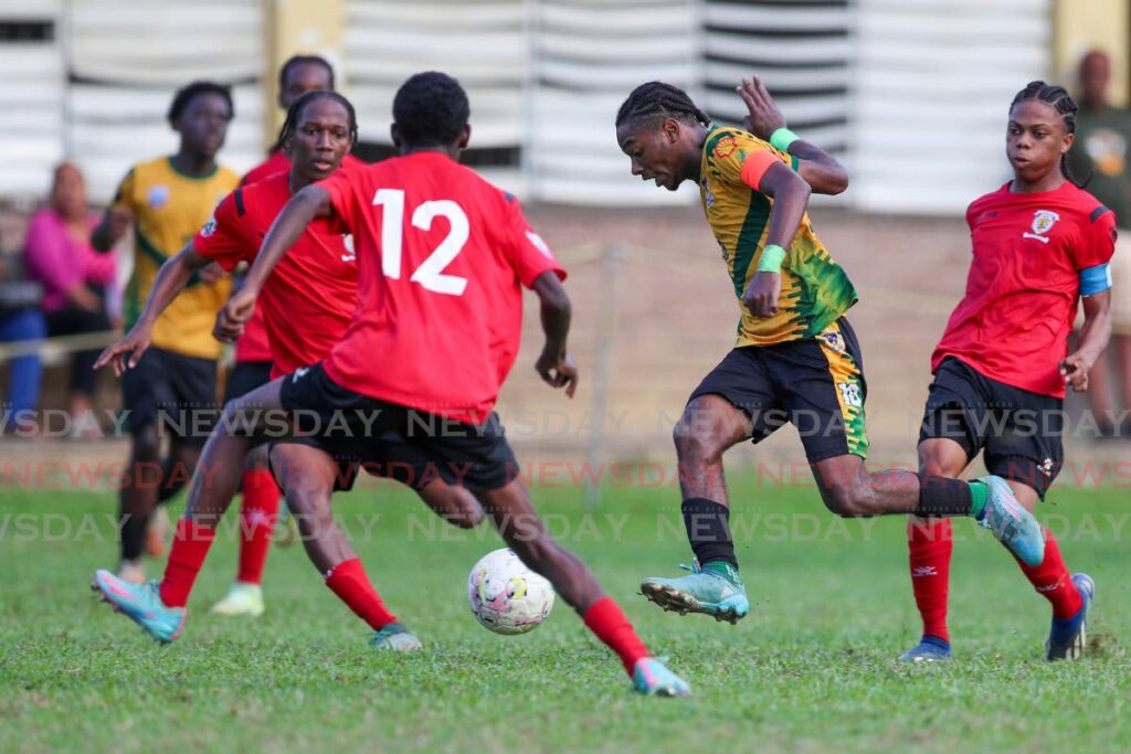 St Benedict's College's Derrel Garcia, centre, tries to weave his way through the St Anthony's defence during the SSFL premiership match at the St Anthony's College Ground n Westmoorings. - File photo by Daniel Prentice