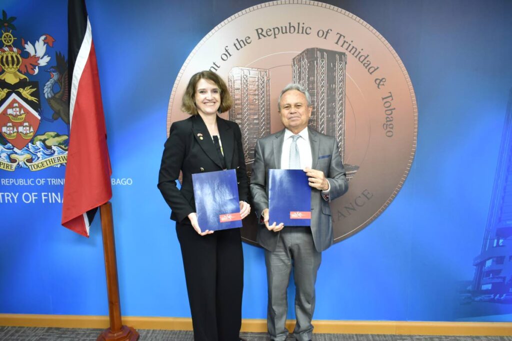 From left, UK High Commissioner to TT Harriet Cross and Finance Minister Colm Imbert holding the signed Memoranda of Understanding between the Finance Ministry and UK Export Finance. - 