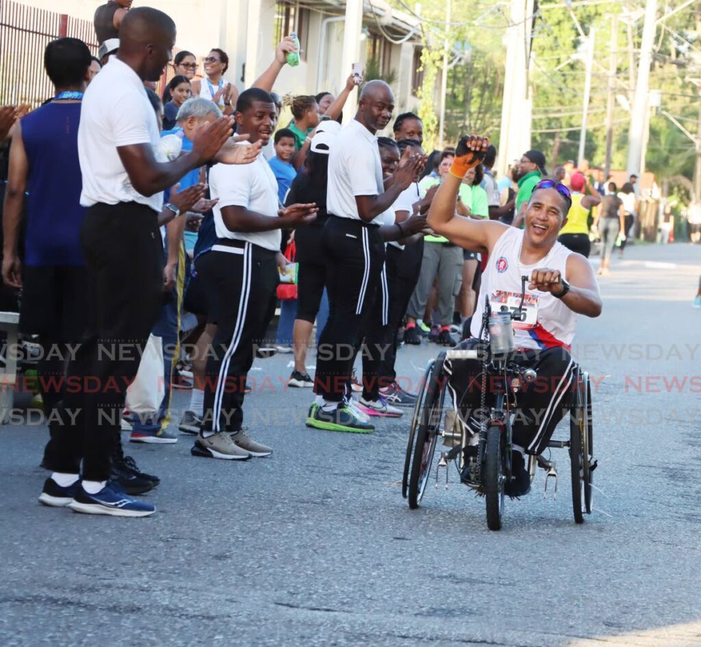 Gerard Asyng is all smiles as he completes the UWI SPEC International half-marathon at the UWI Sports and Physical Education Centre in St Augustine on November 10.  - Photo by Ayanna Kinsale