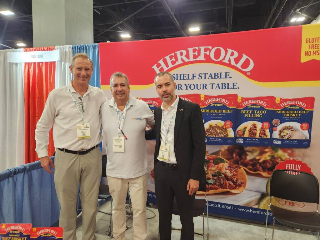 Patrick Ferreira, executive chairman of Furness Shipping & Marketing Ltd, centre, with executives of SAMPCO at the American Food and Beverage Show held in Miami last month.
Photo courtesy Furness. - 