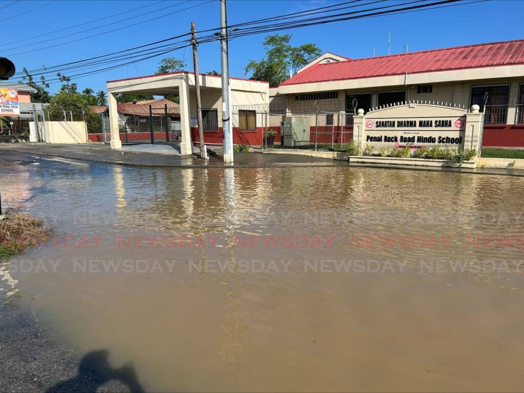 The Kubairsingh Penal Rock Hindu School remained closed on November 13 as floodwater from heavy rain the day before remained on the road.  - Photo by Rishard Khan 