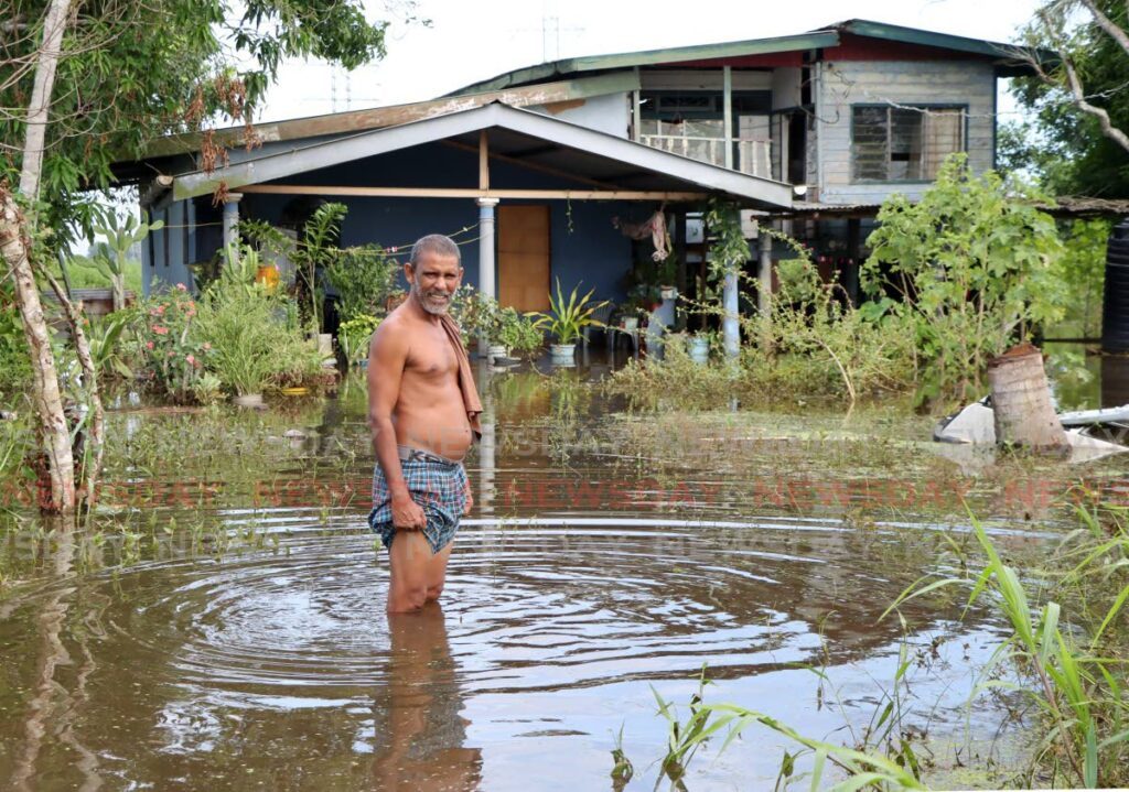 Ramrattan Roopan shows the depth of the floodwater at his home on Pluck Road, San Francique.  - Photo by Ayanna Kinsale