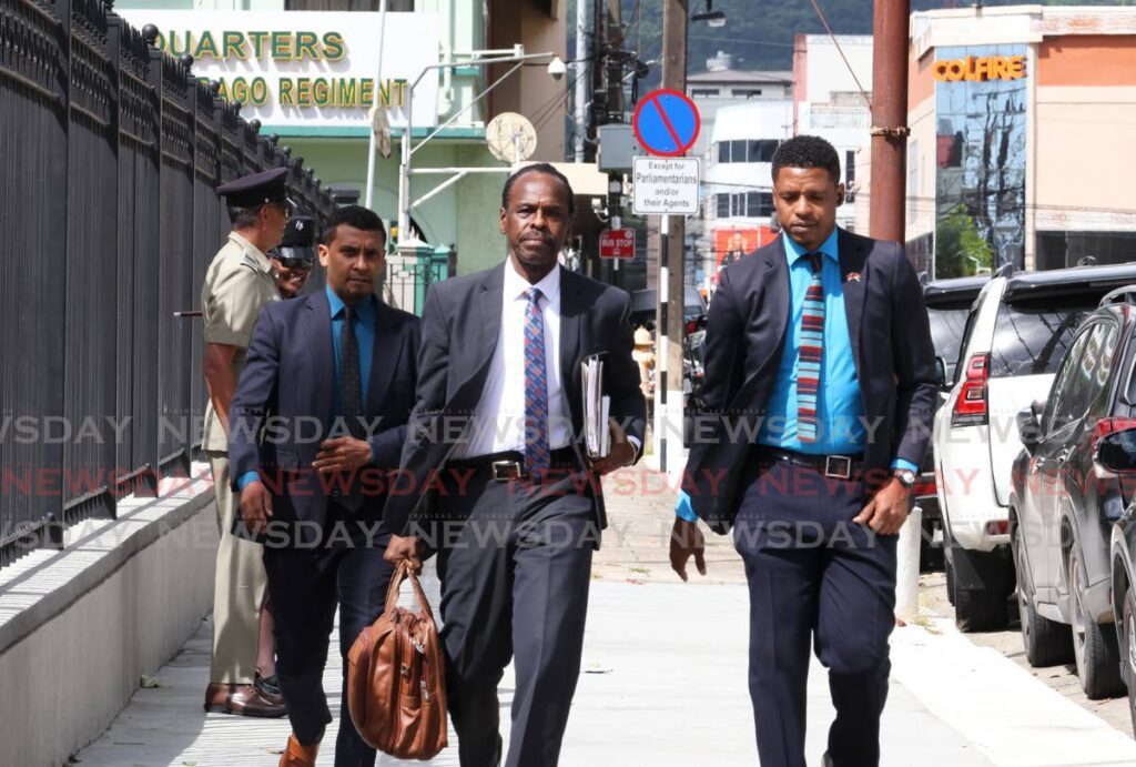 Minister of National Security and Laventille West MP Fitzgerald Hinds, centre, makes his way to the Parliament for a sitting of the Senate at the Red House on Abercromby Street, Port of Spain, on November 29. - Faith Ayoung