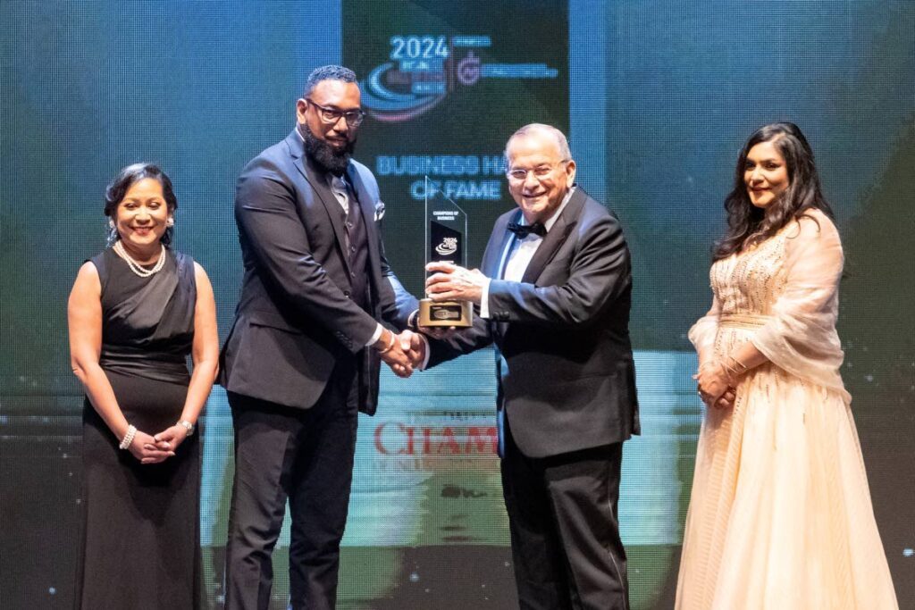 Dr Joseph Ishmael Khan, NGC chairman, centre, hands the Business Hall of Fame award to George Janoura, managing director, Janouras Custom Design Ltd, at the TT Chamber's Champions of Business awards at NAPA on November 7. Flanking them are Karen Yip Chuck, senior VP, TT Chamber, left and Kiran Maharaj, president, TT Chamber. - Photo courtesy NGC