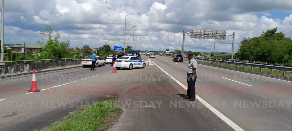 Police cordon off the area at which Winston Thomas, 68, was found dead in the backseat of his car which was abandoned off the Golconda merger on the Solomon Hochoy Highway on November 21. - Photo by Rishard Khan