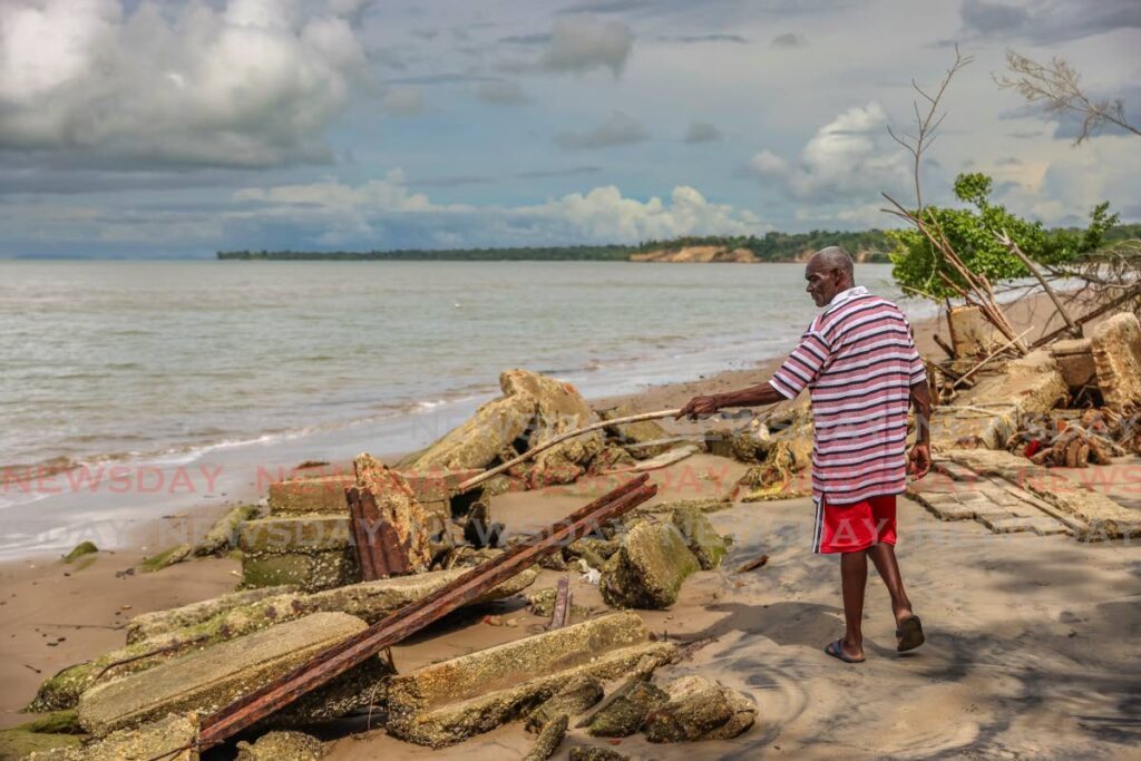 FORGOTTEN RELICS: Bryan Joseph examines pieces of his neighbour's home which was destroyed by a landslide in 2018.  - Photo by Jeff K Mayers