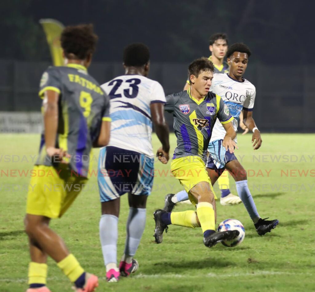 Michael Chaves (C) of Fatima College runs through the middle of the field during the SSFL Coca-Cola Boys’ Intercol North Zone fiinal against Queen’s Royal College, at Diego Martin Sporting Complex on November 21. - Photo by Angelo Marcelle