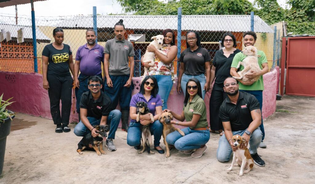 Sara Maynard-Agostini, standing second right, operations manager of the Trinidad and Tobago Society for the Prevention of Cruelty to Animals, her team and some four-legged friends thank the Angostura Foundation team for their generosity. - Photo courtesy Angostura