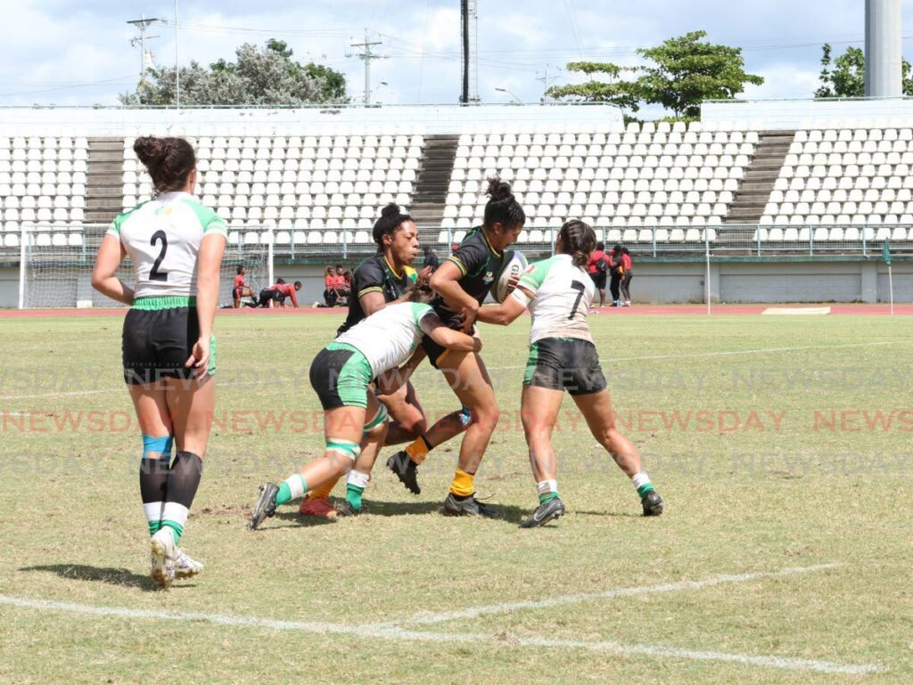 A Jamaica women’s rugby player is tackled by Mexico’s players during their match, on November 23 at the Rugby Americas North Sevens Tournament, at Larry Gomes Stadium, Malabar. - Photo by Faith Ayoung