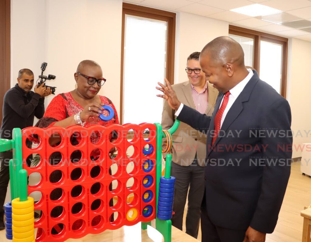 Housing Minister Camille Robinson-Regis and Minister of Youth Development and National Service Foster Cummings play a game of Connect Four during the opening ceremony for the La Horquetta Public Library on Slinger Francisco Boulevard, La Horquetta. - Photo by Ayanna Kinsale