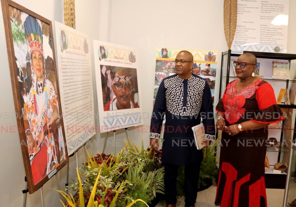 Housing Minister Camille Robinson-Regis and chairman of the board of NALIS Neil Parsanlal look at photos during the opening ceremony for the La Horquetta Public Library on Slinger Francisco Boulevard, La Horquetta. - Photo by Ayanna Kinsale