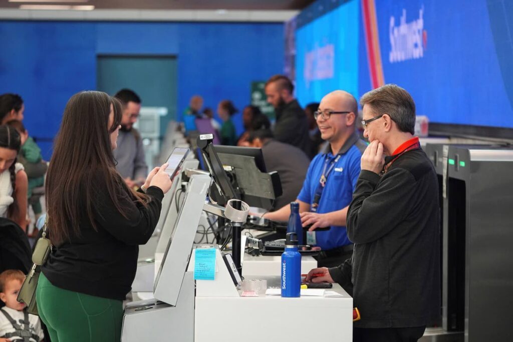 CHECKING IN: A traveller chats with agents at the Southwest Airlines check-in counter in Denver International Airport on November 26 in Denver.  - AP PHOTO 