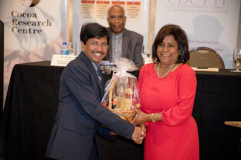 Trade and Industry Minister Paula Gopee-Scoon, receives a gift from professor Pathmanathan Umaharan, head of the Cocoa Research Centre at UWI's 2019 World Cocoa and Chocolate Day Expo. -