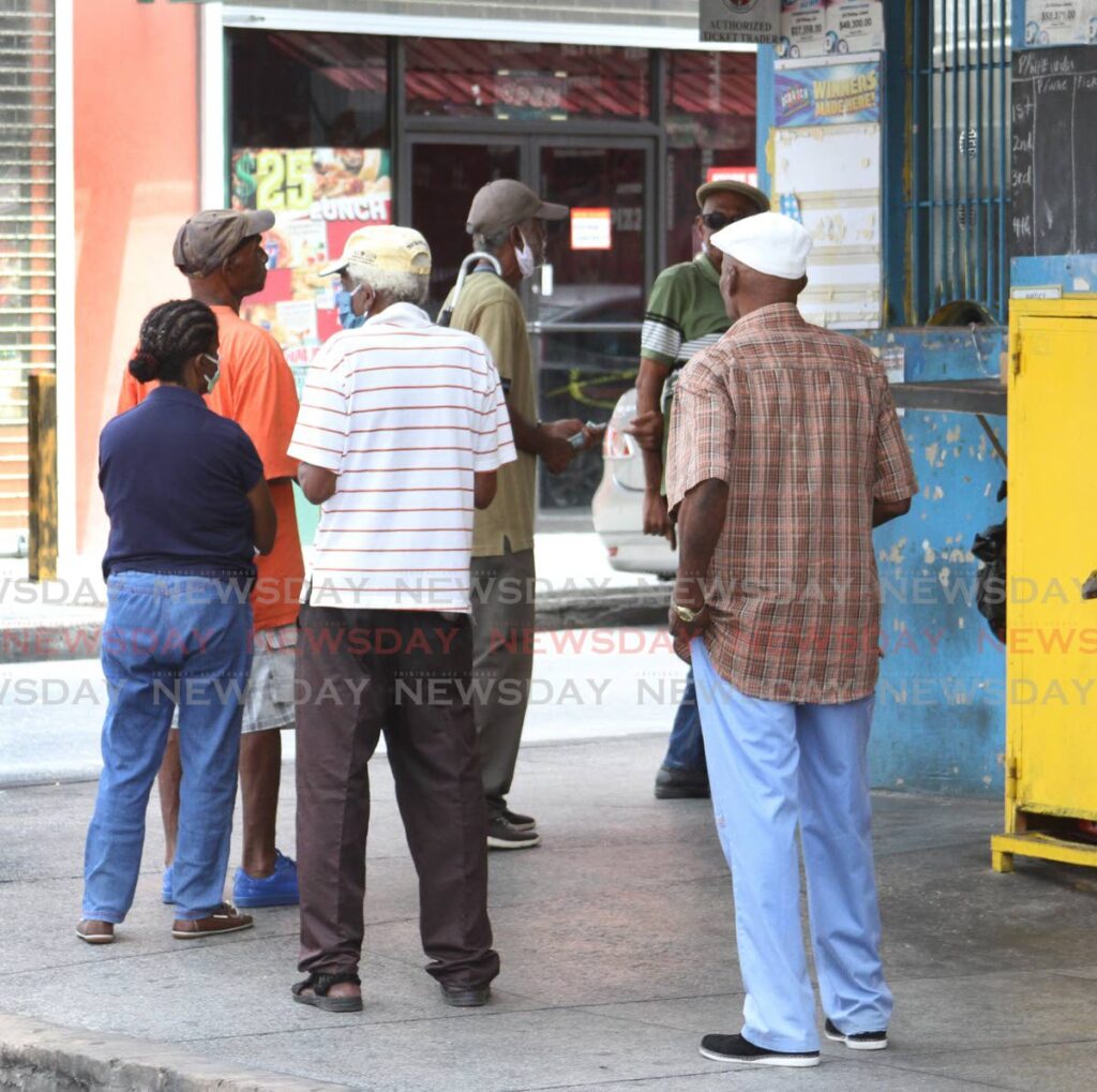 Citizens line up at an NLCB booth on the corner of Farfan and Woodford Street, Arima in June 2020. - FILE PHOTO/Angelo Marcelle