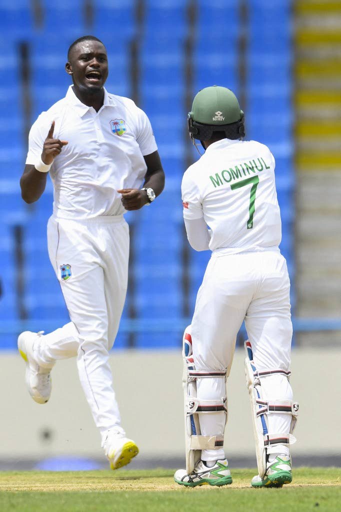 West Indies’ Jayden Seales, left, celebrates the dismissal of Mominul Haque, right, of Bangladesh during the first day of the first Test at the Sir Vivian Richards Cricket Stadium in North Sound, Antigua, on June 16, 2022. - AFP PHOTO