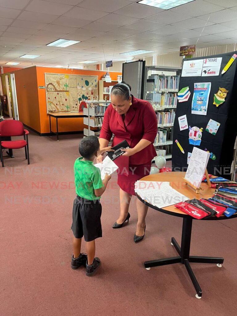 Lisa Morris-Julian, MP for D’Abadie/O’Meara and Minister in the Ministry of Education, gives a little boy a gift for attending the Arima Public Library International Literacy Day event in September 2023. Morris-Julian and two of her children, Xianne and Jesiah, died in a fire at their Farfan Street, Arima home on December 16.  - 