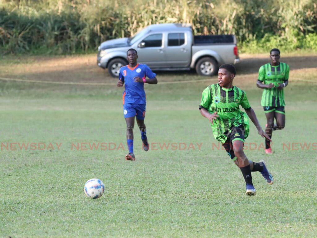 A Trinity Collage player runs full speed to the ball in a match against Scarborough Secondary at Trinity College, Moka, Maraval on November 2. - FAITH AYOUNG