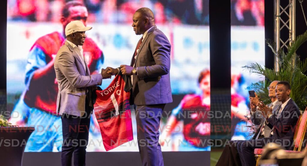 In this November 14 file photo, TT Football Association president Kieron Edwards, right, presents TT legend Dwight Yorke with a jersey during the latter’s unveiling as the new senior men’s head coach, during a ceremony at the Ato Boldon Stadium, Couva.  - Photo by Jeff K Mayers