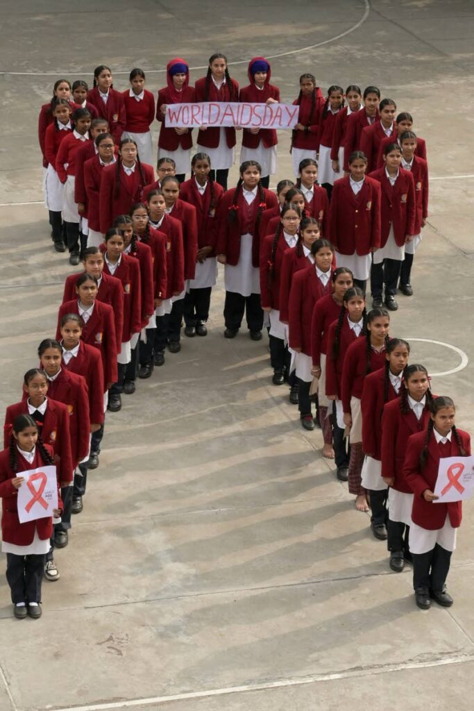 School children stand in a formation of a ribbon as a part of an awareness event on the eve of World AIDS day in Amritsar, India on November 30, 2023. December 1 is World Aids Day. - AFP PHOTO