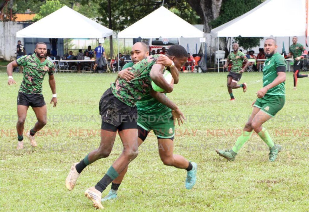 A Defence Force player is tackled during the Harvard International Rugby 7s tournament match, on December 1 against the Harvard Club, at St Mary’s Grounds, Port of Spain.  - Photo by Ayanna Kinsale