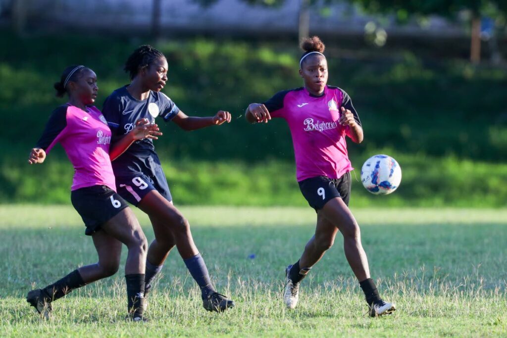 Pleasantville Secondary's Nikita Gosine, right, and Natalia Gosine, left, close down the attack from Miracle Ministries' Kyanna Isaac during the SSFL Intercol Girls semifinal at the Lewis Street grounds on December 1, in San Fernando. - Photo courtesy Daniel Prentice