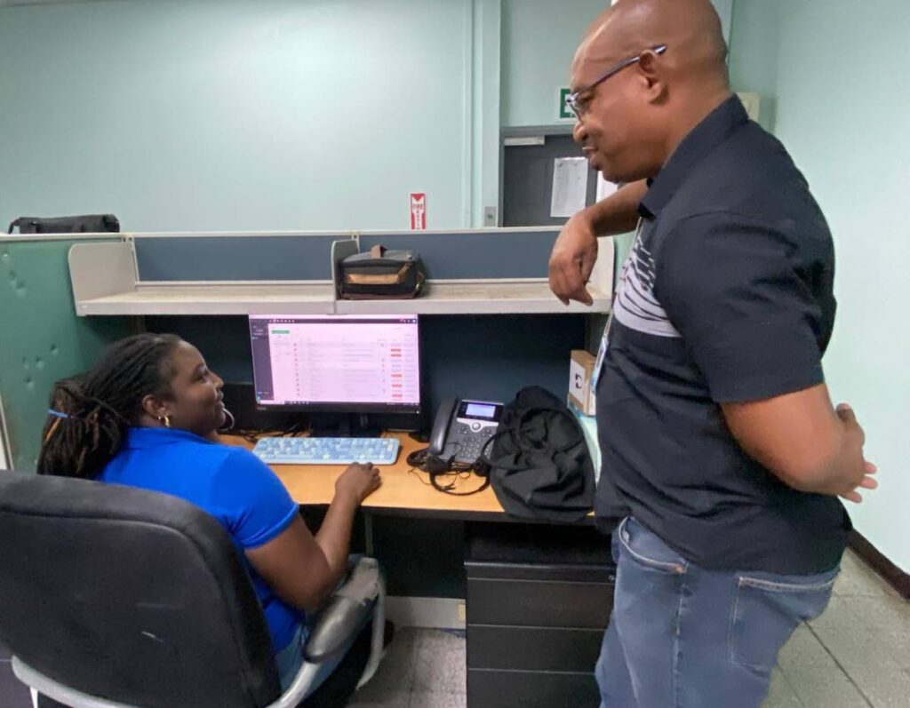 WASA CEO Keithroy Halliday speaking with a WASA call-centre worker during his tour of the head office on December 1. - Photo courtesy WASA