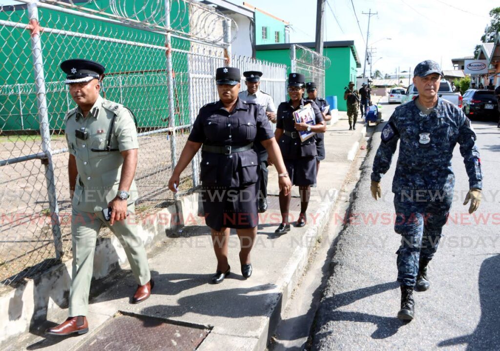 ACP Wayne Mystar, left, leads officers on the confidence patrol on December 2 in Enterprise, Chaguanas. - Photo by Angelo Marcelle