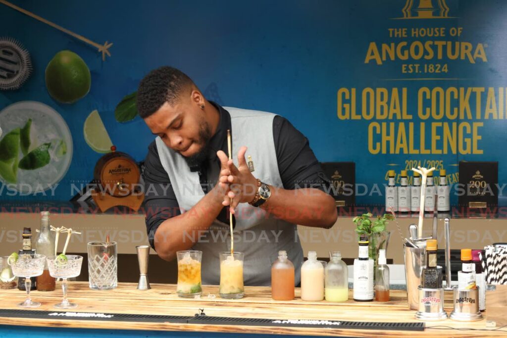 Ronaldo Auguste mixes his cocktail, Spiced Tamarind at the Angostura Global Cocktail Challenge at Nube Nueve Deck, Valpark on Morequito Avenue, Valsayn on December 3. - Photo by Faith Ayoung