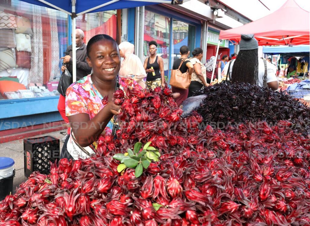 Temeka Williams, fondly called the Princess of Sorrel, heaps her latest harvest of red sorrel for shoppers on Charlotte Street, Port of Spain on December 6. Williams's father is  known as the King of Sorrel.  - Photo by Faith Ayoung