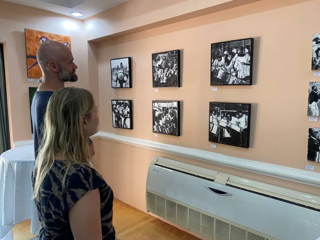 German tourists look at paintings at The Secret Garden exhibition at Coco Reef Resort and Spa, Crown Point, recently.  - Photo courtesy Visual Styles 