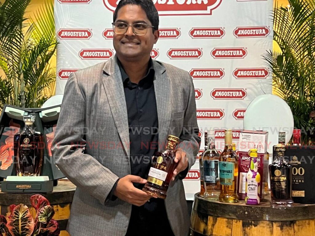 Angostura’s business efficiency and shared services executive manager Rahim Mohammed holds the 1824 bottle of rum at the earning call meeting at the House of Angostura, Laventille on December 9. - Photo by Enrique Rupert