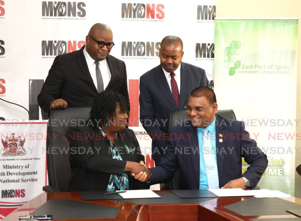 From left, chairman of the East Port of Spain Development Company Ltd Hillan Morean and Minister of Youth Development and National Service Foster Cummings look on as assistant general manager Nissa Hosten-James and MYDNS acting permanent secretary  Narine Charran sign a memorandum of agreement at the ministry on Elizabeth Street, St Clair on December 13.  - Photo by Faith Ayoung