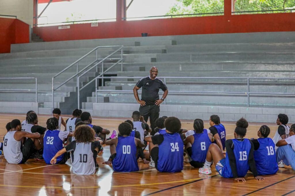 Coach Anthony Roy (standing) speaks to a group of basketballers during the Island Prospects College and University Basketball youth showcase at the Maloney Indoor Sporting Arena on December 11,2024. Photo courtesy Garvin Warwick.  - 