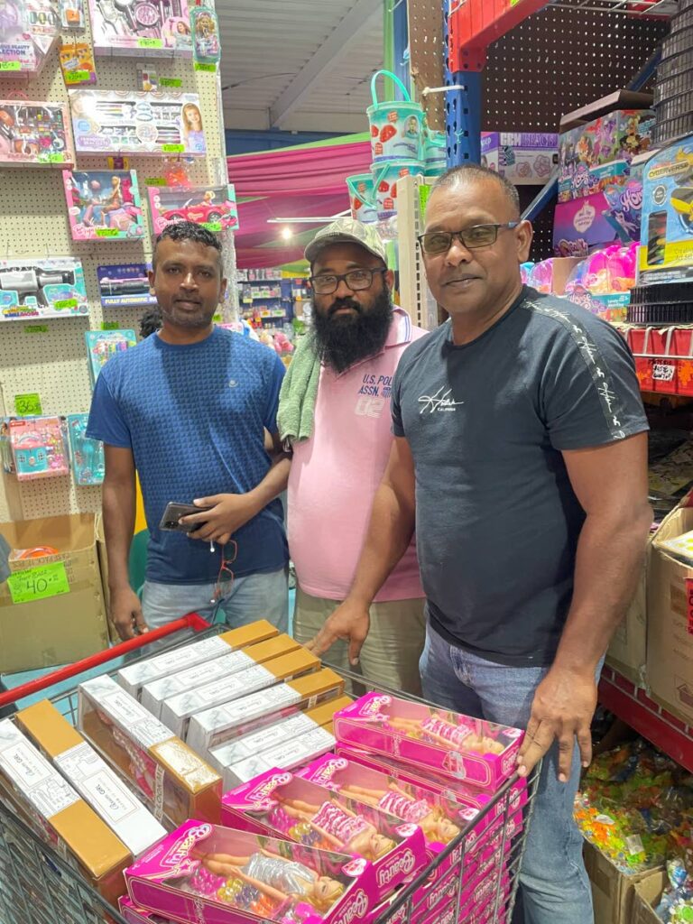 Members of the Navet United Sports Club, from left, Mohan Rampersad, president Roger Gumai and Steve Sankar shop at MET Wholesale Ltd for toys for the club's annual Christmas motorcade. - 