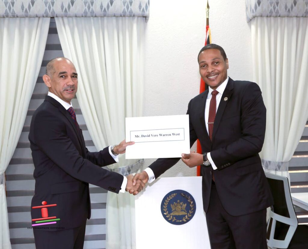 Attorney David West, left, receives his instrument of appointment from acting President Nigel de Freitas on December 13, at President's House after he was appointed to serve as director of the Police Complaints Authority for a third consecutive time. - Photo courtesy Office of the President