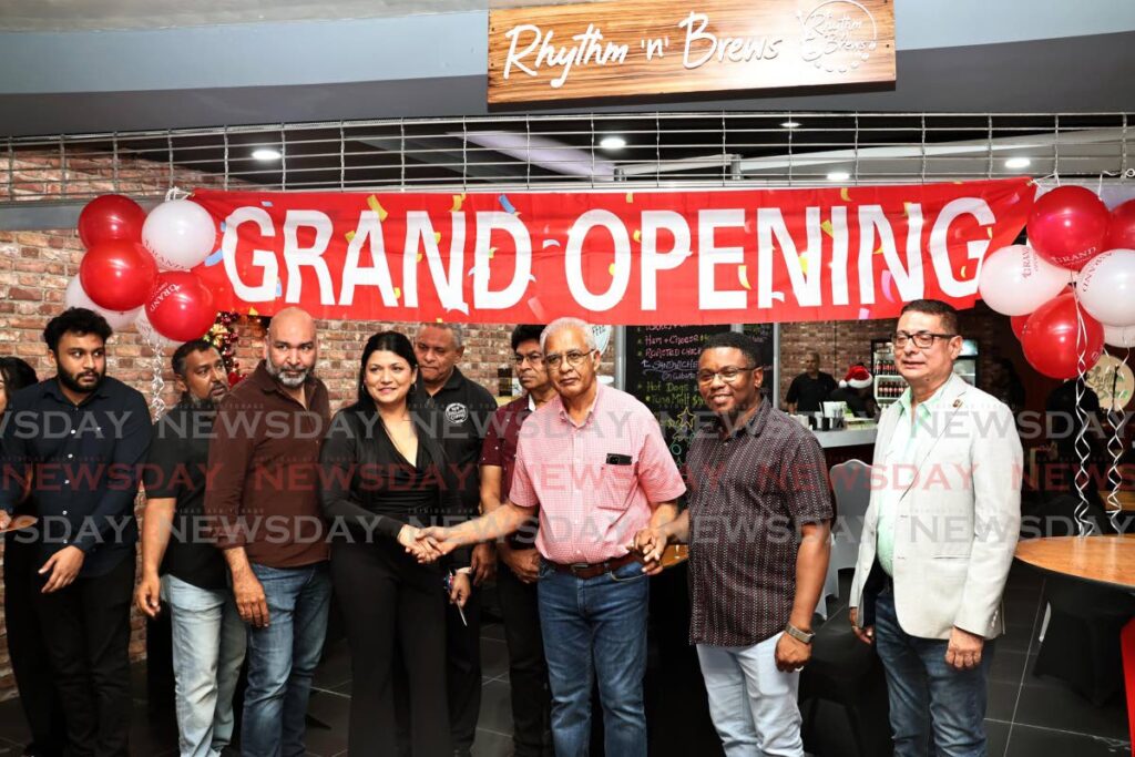 Owner Sarah Ragoonath and San Fernando Mayor Robert Parris shake the hand of managing director of Gulf City Mall, Seunarine Sanmook at the opening of Rhythm 'n' Brews Coffee Shop and Music Café, Gulf City Mall. - Photo by Lincoln Holder 