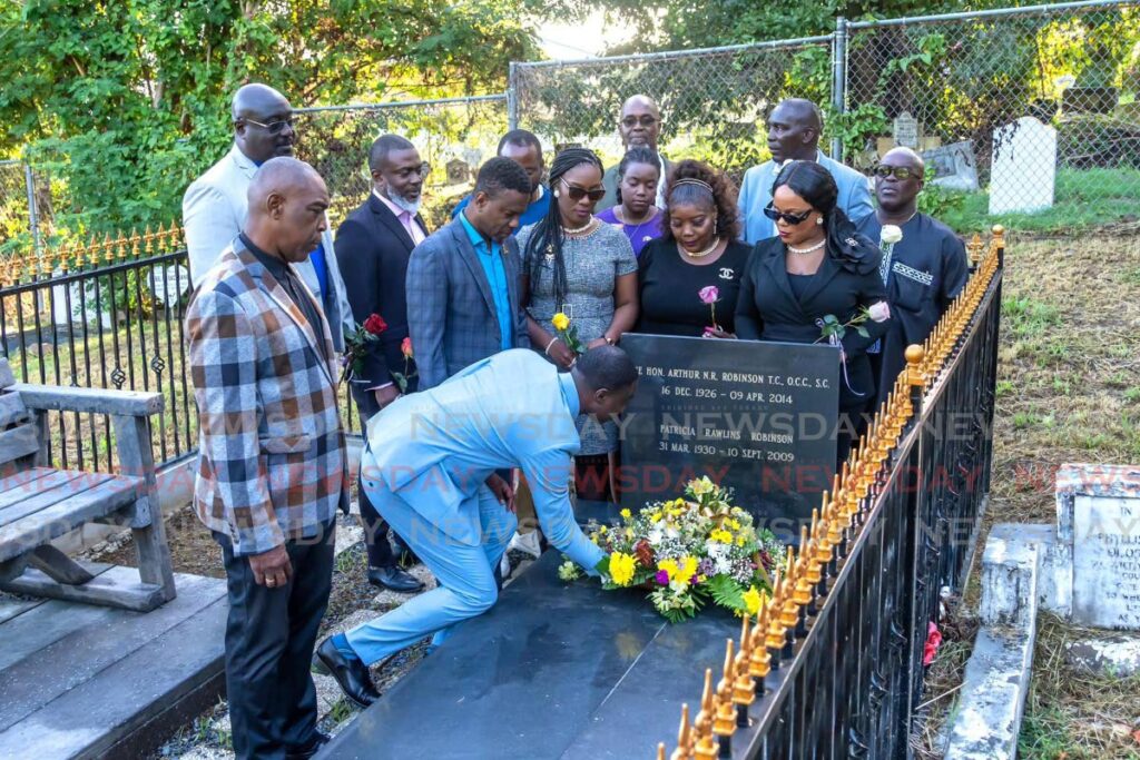 Chief Secretary Farley Augustine lays a wreath at the tombstone where former prime minister ANR Robinson was buried in Bacolet on Monday. - THA