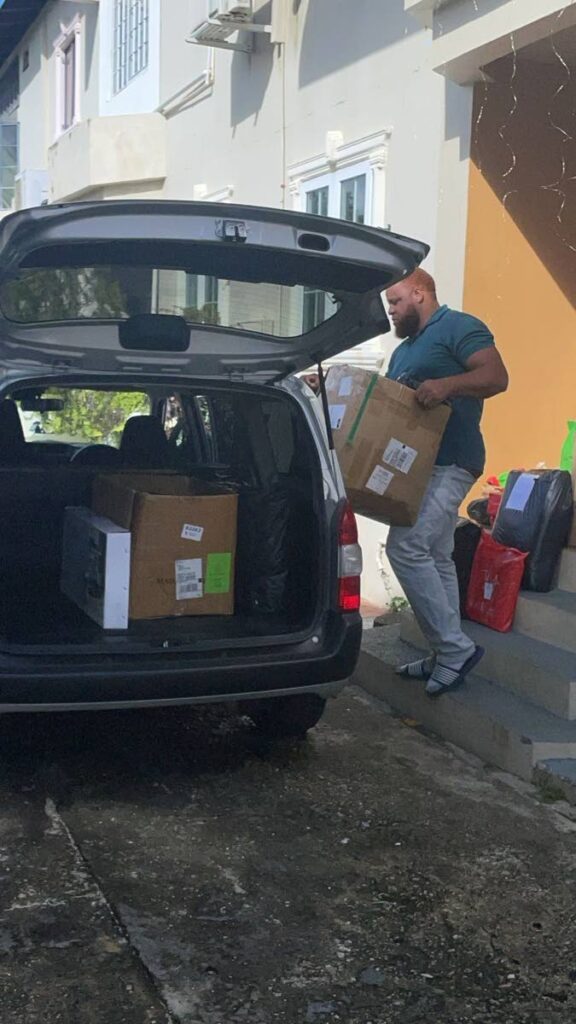 A courier loads packages into his vehicle, ready for delivery.  - 