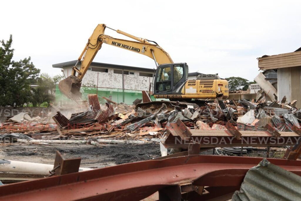 An excavator piles up rubble that was once part of the Chinese Association building on St Ann's Road, Port of Spain on December 19. - Photo by Faith Ayoung