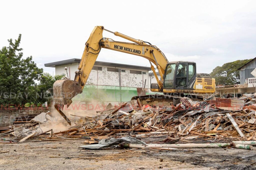 An excavator piles up rubble that was once the Chinese Association building at 7 St Ann's Road, Port of Spain, on December 19. - Faith Ayoung