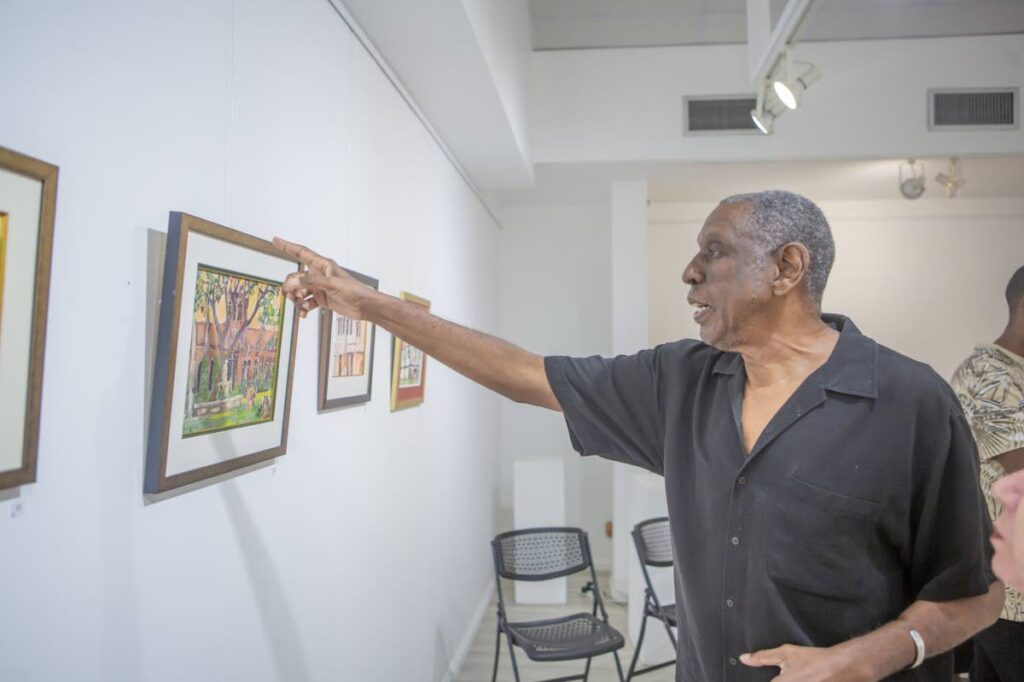 Roger Boothman with one of his paintings featured at an exhibit held at the Art Society of TT in 2024. - File photo