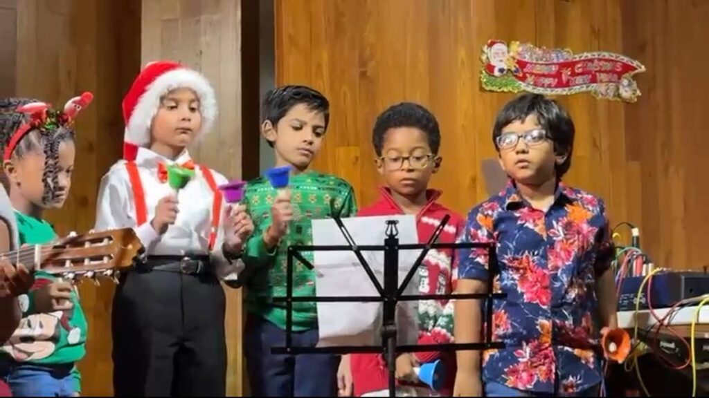 From left, Akicia Matthew, Nathon Ballah, Aryan Sieunarinesingh, Ryden Miguel and Emerson Jewnath perform Jingle Bells alongside the ILM guitar ensemble. - 