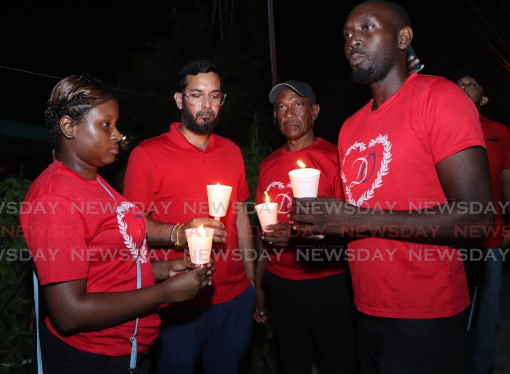 Friends of Arima MP Lisa Morris-Julian honour her memory during a candlelight vigil at Printeryville, O'Meara Road, Arima on December 20.  - Photo by Angelo Marcelle