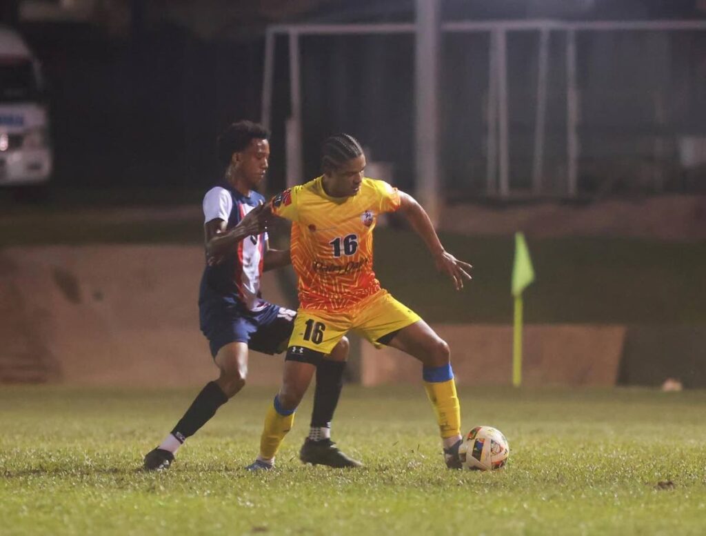 AC PoS defender Liam Burns (R) shields the ball from Caledonia AIA's Tyrese Williams during their TT Premier Football League match at the St James Police Barracks on December 15. Photo courtesy TTPFL.  - 