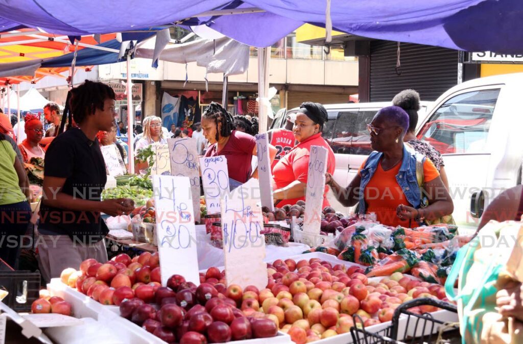 BARGAIN HUNT: People line up for market goods as they do their last-minute Christmas shopping on Charlotte Street in Port of Spain on December 23. - Photos by Faith Ayoung