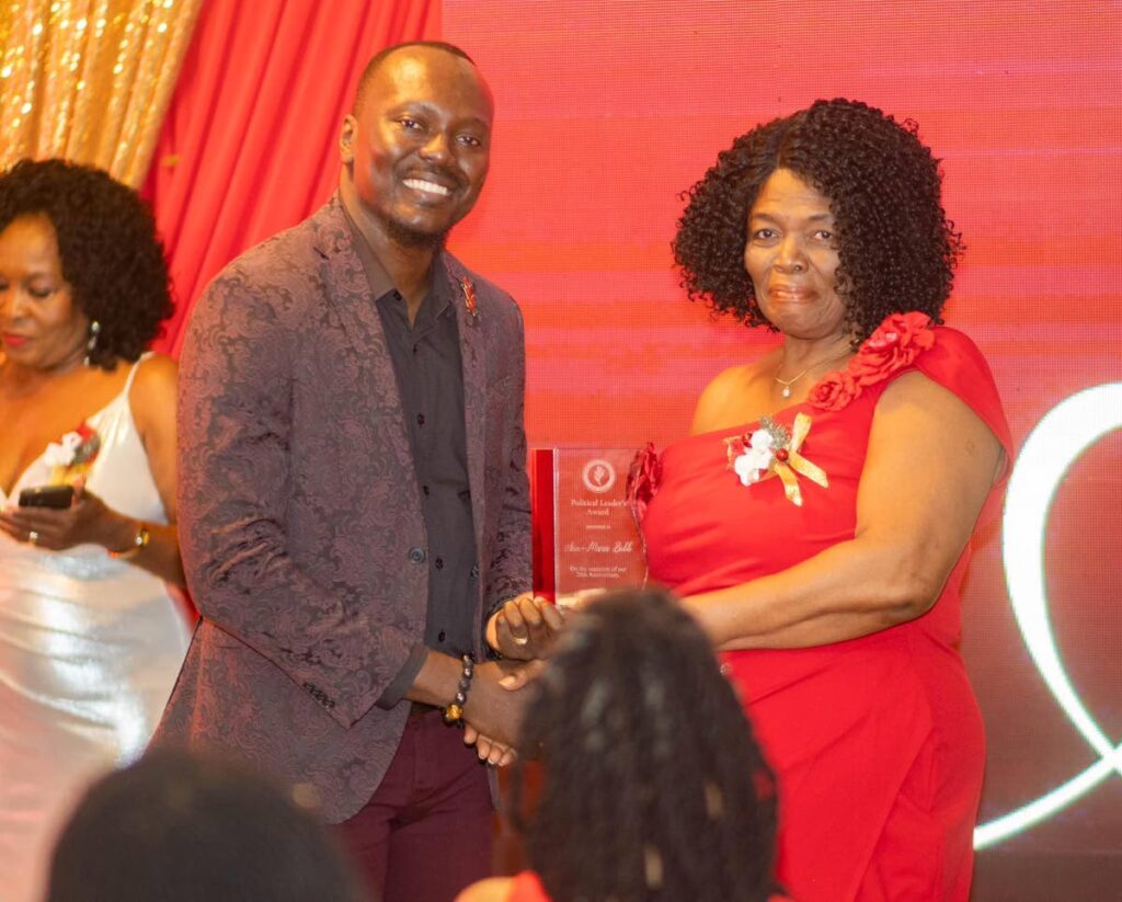 PNM Tobago Council leader Ancil Dennis, left, gives an award to Ann-Marie Bobb, one of the party's stalwarts, at an anniversary event on December 22, Fairways Restaurant and Bar, Lowlands.  - 