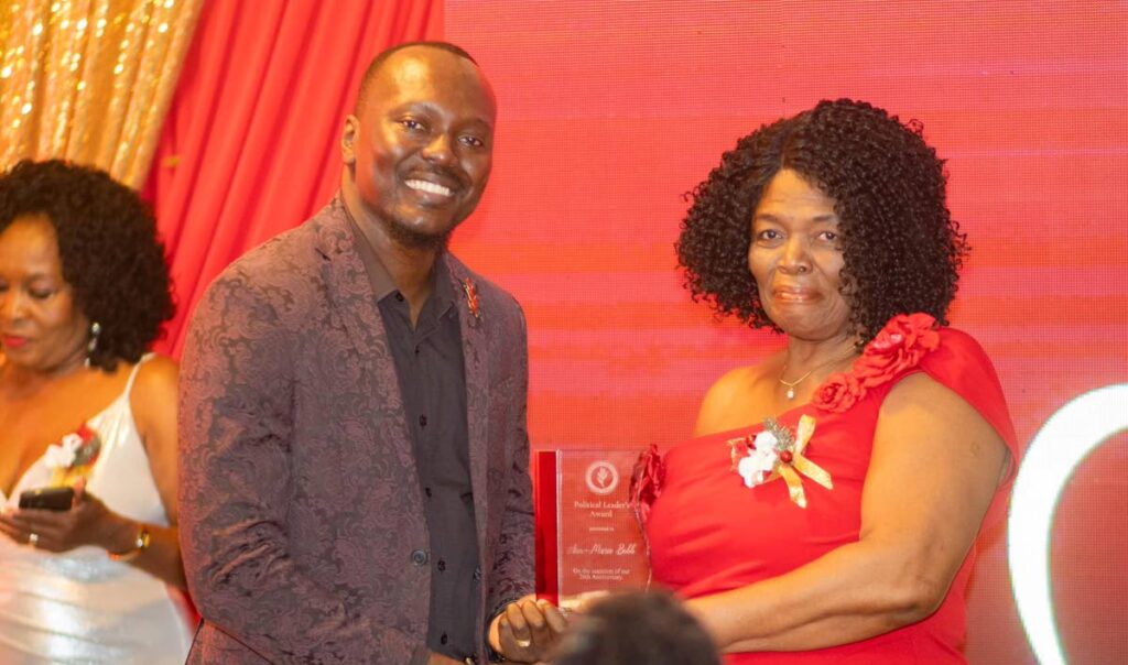 PNM Tobago Council leader Ancil Dennis, left, gives an award to Ann-Marie Bobb, one of the party's stalwarts, at an anniversary event on December 22, Fairways Restaurant and Bar, Lowlands.  - 