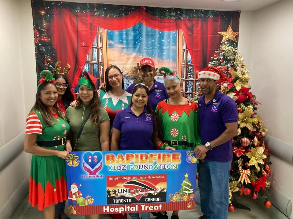 Members of the Rapidfire Kids Foundation, including president Kevin Ratiram, right, at the annual Christmas treat at the San Fernando Teaching Hospital. - 