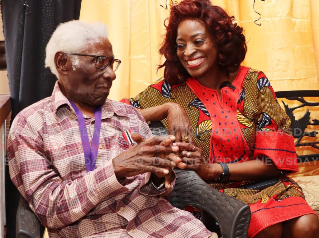 Centenarian George Alexander, front, left, celebrates his 100th birthday on Christmas Eve with Social Development Minister Donna Cox at his home on Moraldo Street, Maraval, on December 24.  - Photo by Ayanna Kinsale